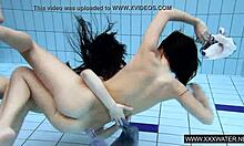 shaved brunette with big tits enjoys underwater lesbian fun in the pool