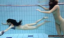 shaved brunette with big tits enjoys underwater lesbian fun in the pool