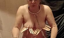 Female slave explores self-bondage with clamps, piss, and belt restraints