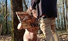 slave in pillory gets humiliated outdoors