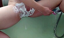 Mature woman shaves her smooth area in the shower.