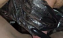 Glove-wearing milf milks cock with hands.