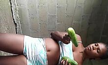 Local black African teen explores cucumbers amid unfinished buildings in a teasing 5 and 6 vibe