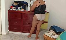 curvy chubby amateur folds clothes while tidying messy room