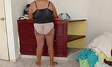 curvy chubby amateur folds clothes while tidying messy room