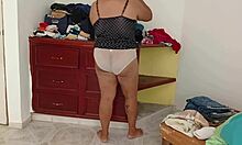 curvy chubby amateur folds clothes while tidying messy room