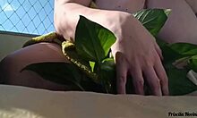 naked tattooed babe waters plants on public balcony