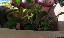 naked tattooed babe waters plants on public balcony