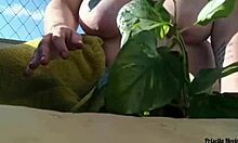 naked tattooed babe waters plants on public balcony