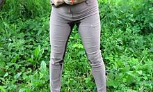 wet milf soaks jeans with hot piss in public garden outdoors