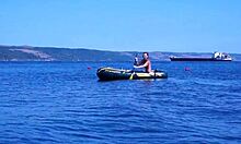mature couple relaxes on boat in volga river water wearing bikinis