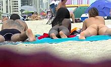 Moglie e fidanzata si spogliano e si lasciano andare in una spiaggia affollata