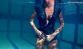 Blonde Feher shows off big firm tits underwater.