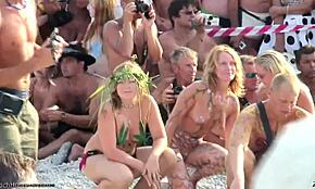 Nakna flickvänner rockar vild kroppsmålning på stranden