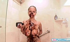 Teen Paris Milan spreads chocolate over body in shower.