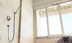 During her college travels, the young asian student bathes while washing clothes in the shower