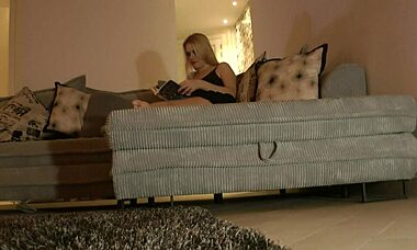 Blonde milf in miniskirt flashes pussy and long legs on couch while trying to read
